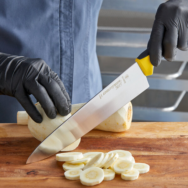 A person with black gloves cutting bananas with a Dexter-Russell 360 Series chef knife.