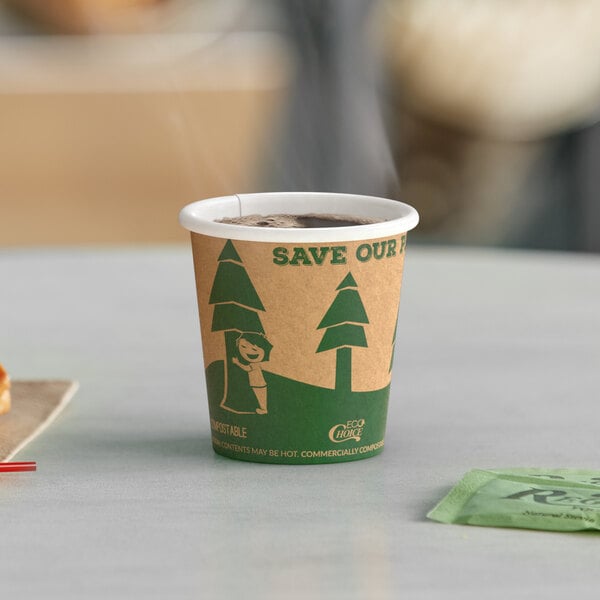 A close-up of an EcoChoice Kraft paper hot cup with a tree print filled with coffee on a table.
