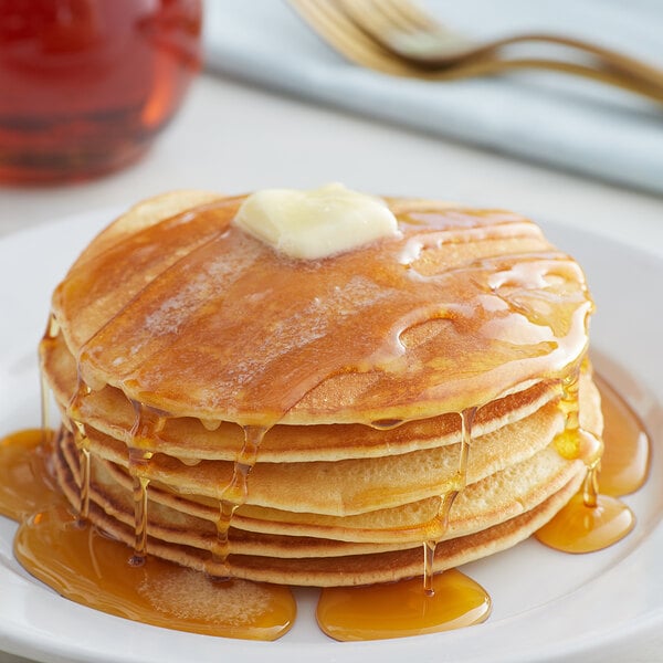A stack of Golden Dipt Pancakes with butter and syrup on top.