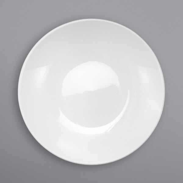 A white International Tableware Torino deep coupe porcelain pasta plate on a gray surface.