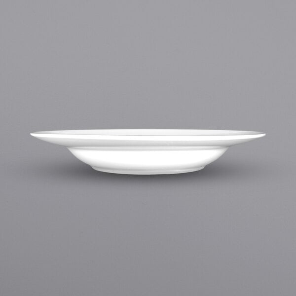A close up of an International Tableware Bristol white porcelain pasta bowl with a wide rim.