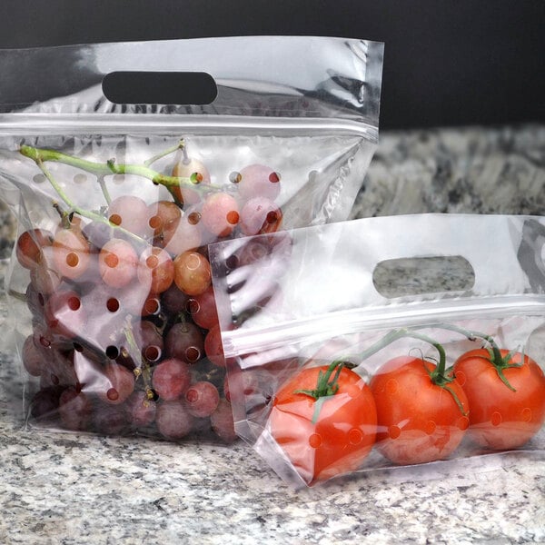 Two clear plastic vented zipper seal pouches of tomatoes and grapes.