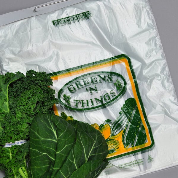 A clear plastic bag with green text reading "Large Print Greens Bag" filled with green vegetables.