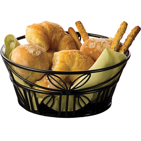 An American Metalcraft black wrought iron bread basket filled with bread rolls and pretzels.