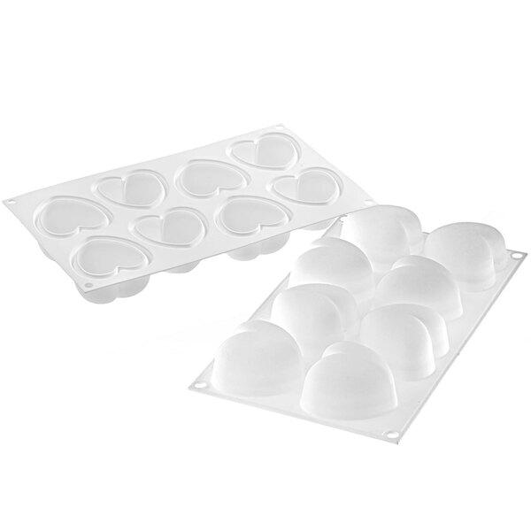 A white Silikomart silicone baking mold with heart-shaped cavities and a border filled with heart-shaped ice cubes.