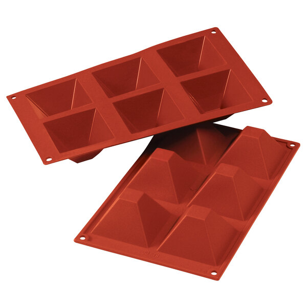 A red Silikomart silicone mold with six pyramid shaped compartments.