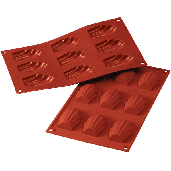 A close-up of a red Silikomart silicone Madeleine baking mold with 9 compartments.