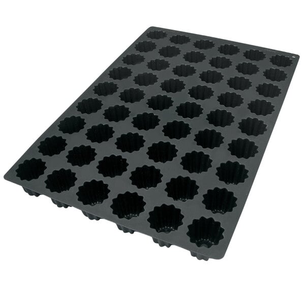 A black Silikomart silicone baking mold with small holes.