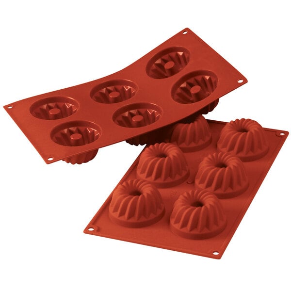 A close-up of a red Silikomart silicone baking mold with six Gugelhopf cavities.