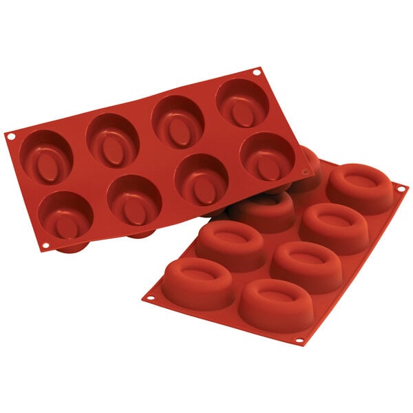 A close-up of a red silicone mold with oval cavities.