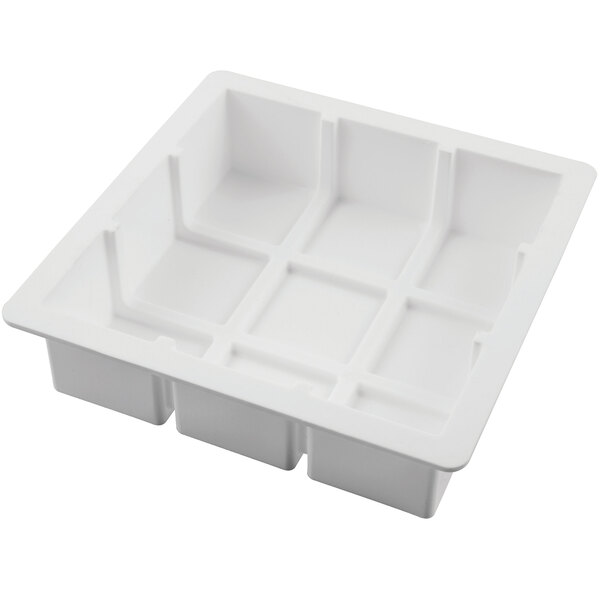 A white Silikomart silicone baking mold with four square cavities.