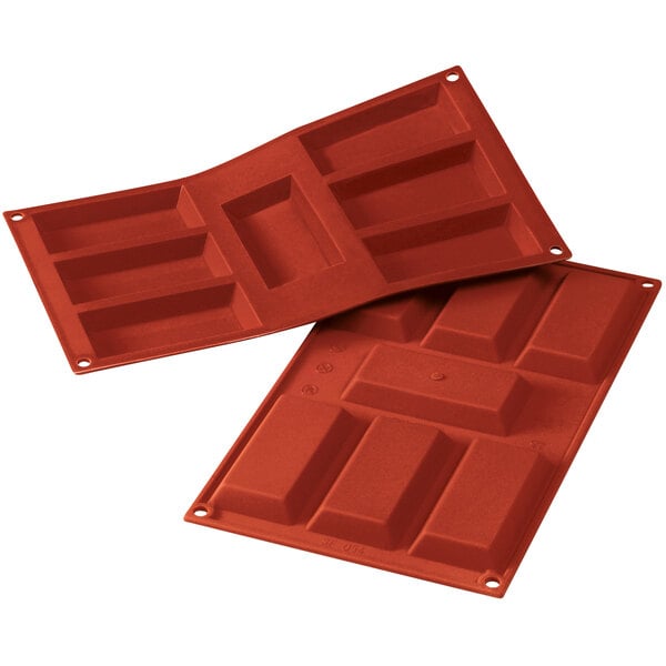 A close-up of a red Silikomart silicone baking mold with 7 Financier cavities.