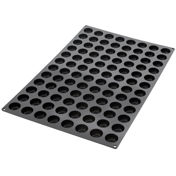 A black Silikomart baking mold tray with 96 pomponette cavities.