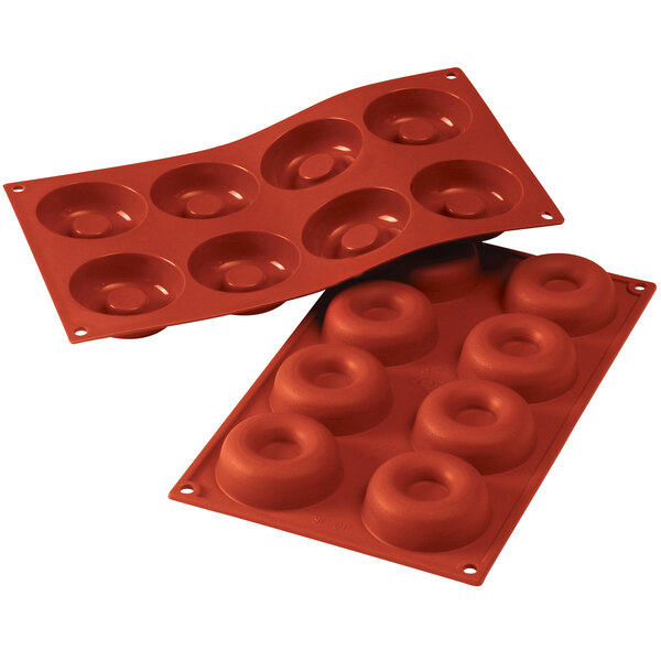 A red silicone baking tray with 8 circular cavities.