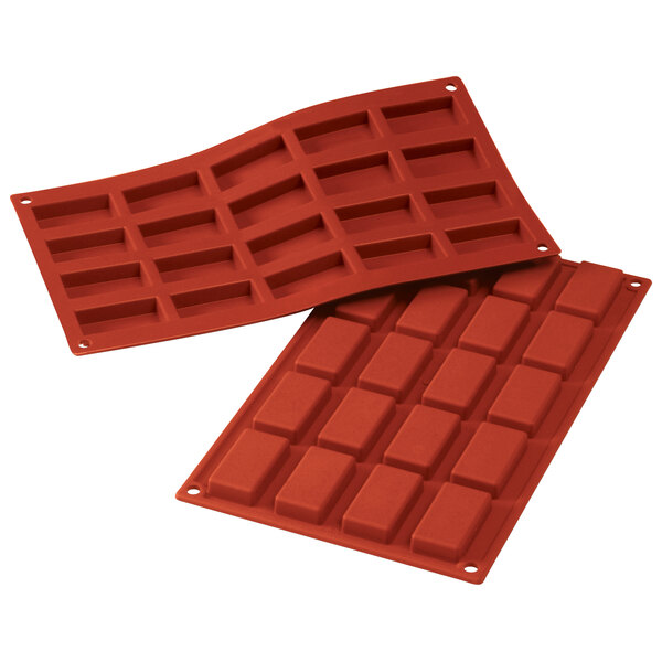 A close-up of a pair of red Silikomart silicone baking molds with different shapes.