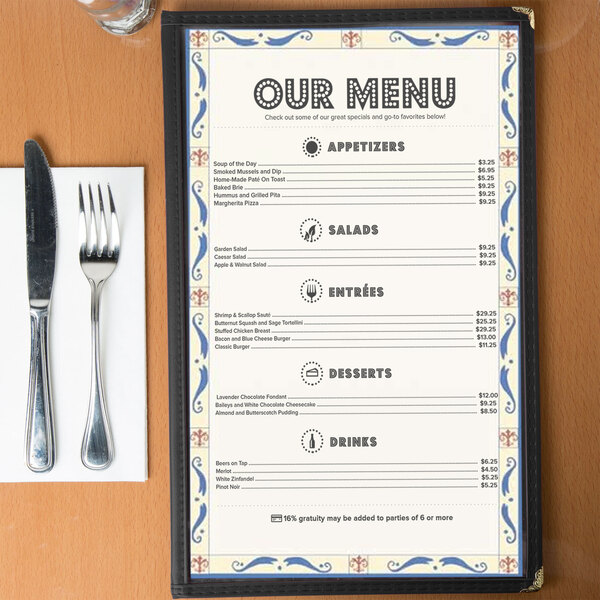 An 8 1/2" x 14" menu with Mediterranean border on a wood table with a fork and knife.