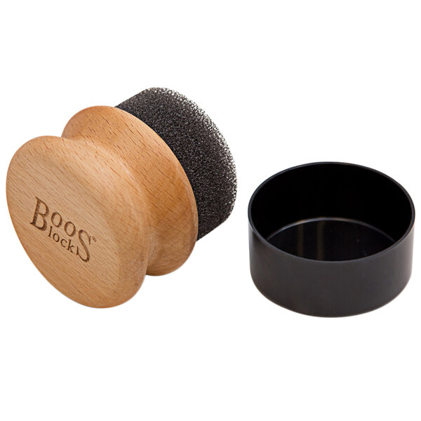 A wooden round applicator with a black lid.