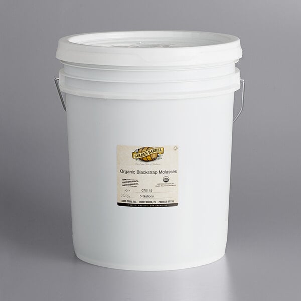 A white Golden Barrel bucket with a lid and a label.