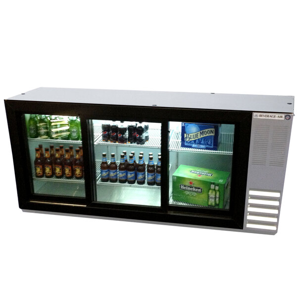 A Beverage-Air stainless steel back bar refrigerator with sliding glass doors filled with bottles of beer.
