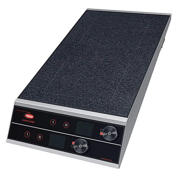 A black and silver rectangular Hatco dual induction range with knob controls on a counter.