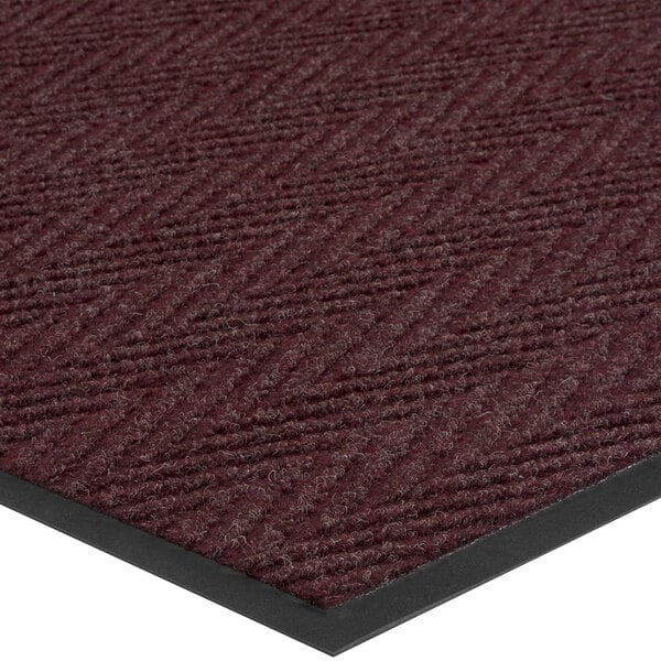A burgundy Lavex carpet mat with a black border in a chevron pattern.
