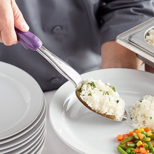 A person using a Vollrath Jacob's Pride basting spoon to serve rice and vegetables.