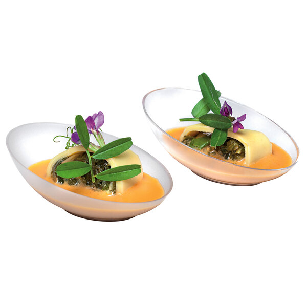 Two Solia transparent tasting mini dishes filled with food on a table.