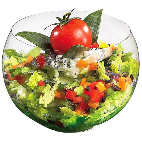 A Solia transparent plastic salad bowl filled with lettuce and a tomato.
