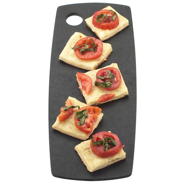 A rectangular black Cal-Mil flat bread board with food on it, including cheese and tomatoes.