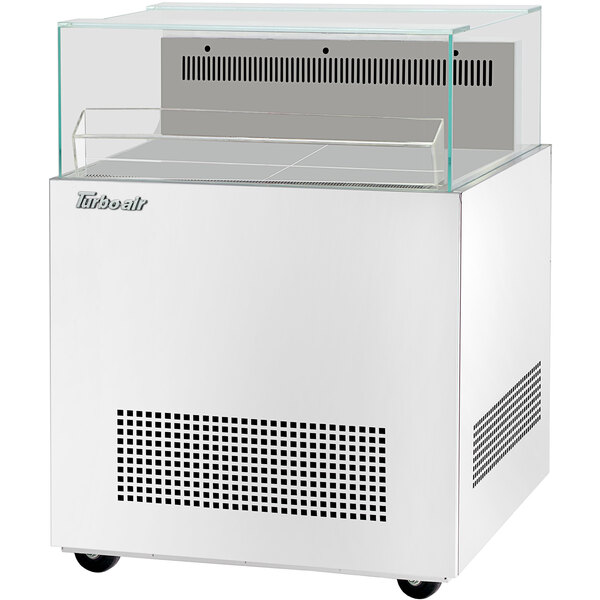 A white rectangular Turbo Air open display merchandiser with a glass top.