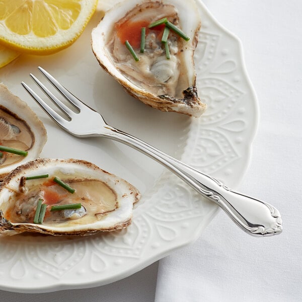 A plate of oysters with a fork and lemon on it.