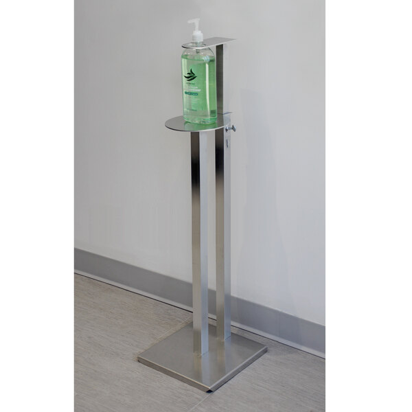 An Advance Tabco sanitizer stand with a bottle of hand sanitizer on it.