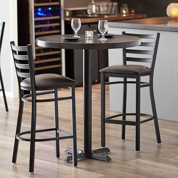 A Lancaster Table & Seating round bar table with chairs and wine glasses.