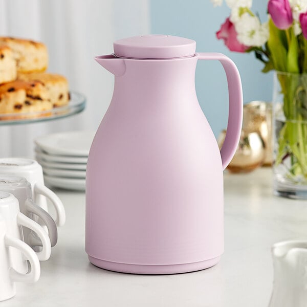 An Acopa purple thermal carafe with white cups on a table.