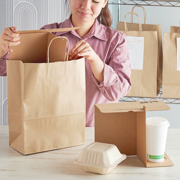 A woman opening a Sabert white food container from a brown paper bag.
