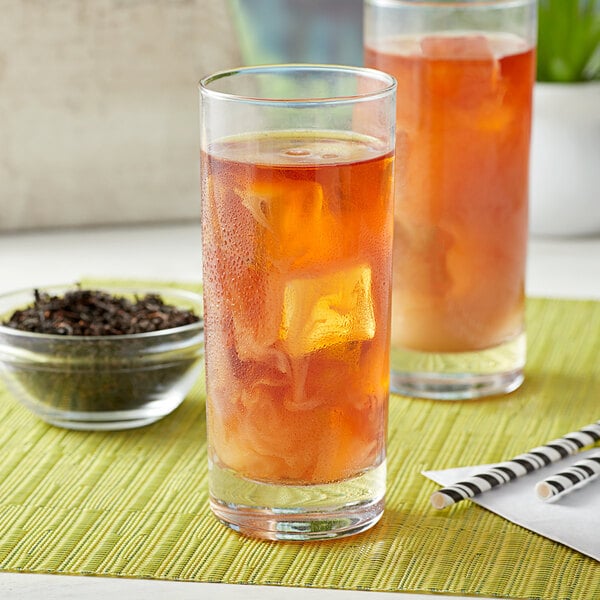 A glass of iced black tea with ice cubes.