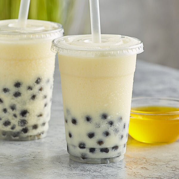 Two cups of Bossen kumquat syrup in bubble tea with straws.