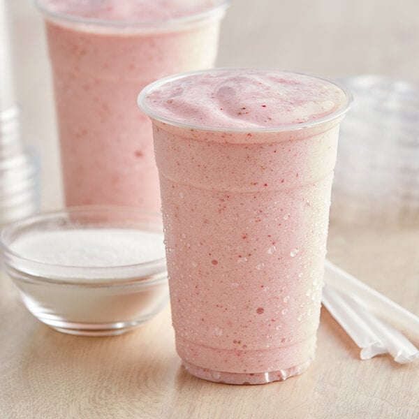 A bowl of Bossen Smoothie Stabilizer Base Powder mix on a table with two smoothies and straws.