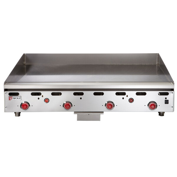 A Wolf stainless steel liquid propane griddle with red knobs.