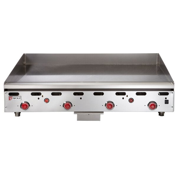 A Wolf stainless steel natural gas griddle with red knobs.