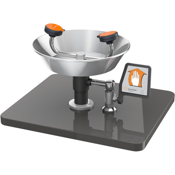 A Guardian Equipment eye and face wash station with a stainless steel bowl and orange handles.