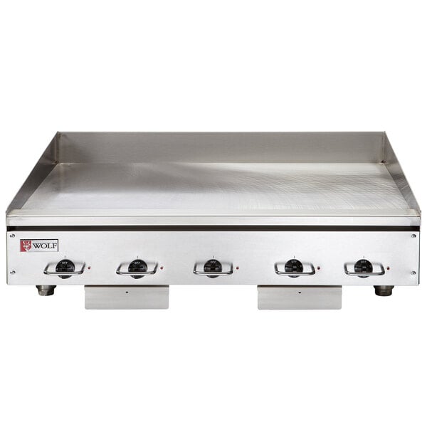 A Wolf stainless steel electric countertop griddle with chrome surface and knobs.