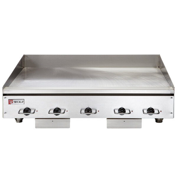 A Wolf stainless steel countertop griddle with chrome plate and knobs.