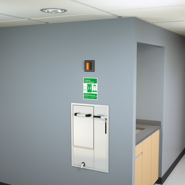 A wall with a white door and a sign for a Guardian Equipment recessed safety station.