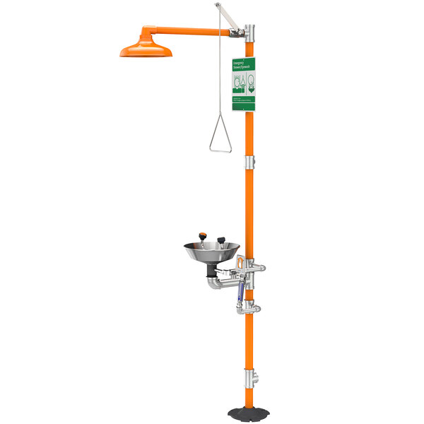 An orange and green Guardian Equipment eye wash and shower safety station with a sign pole.