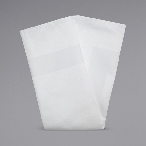 A folded white Snap Drape Milan satin band cloth napkin on a gray surface.