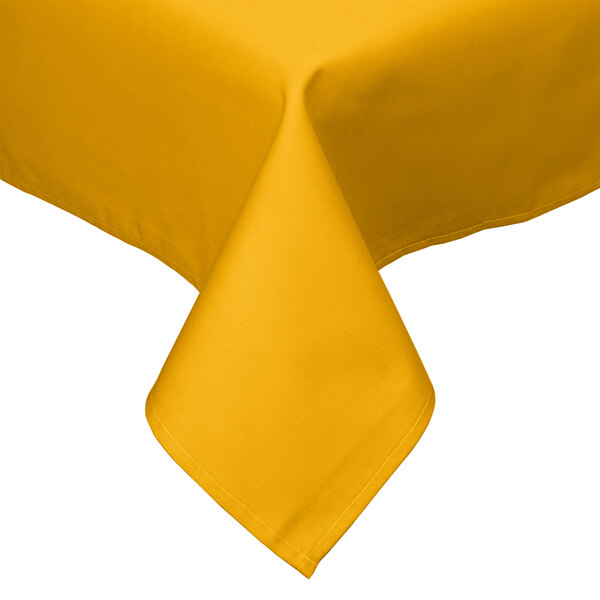 A folded gold tablecloth on a table.