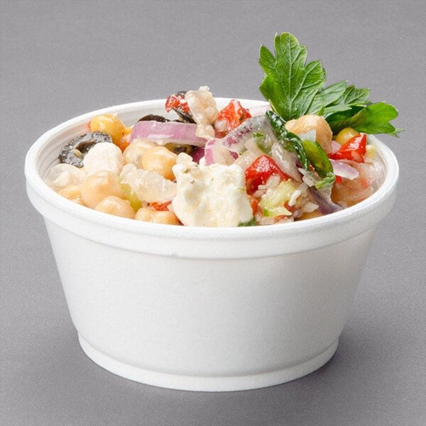 A Dart white foam food container filled with a salad.