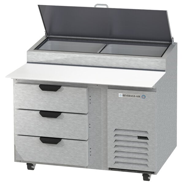 A Beverage-Air stainless steel refrigerated pizza prep table with clear lids over three drawers.