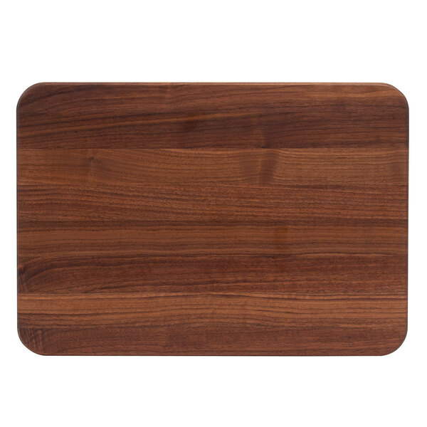 A John Boos walnut wood cutting board with hand grips on a wood surface.